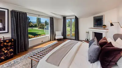 a living room with a white bed and a large window at Howard Hughes Estate in Los Angeles