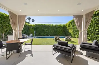 a patio with a table and chairs and a pool at The Artezen Villa by Stay Awhile Villas in Los Angeles