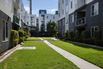 an apartment yard with grass between two buildings at Blueground Playa Vista pool nr Ballona Creek LAX-1376 in Los Angeles