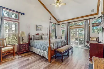 a bedroom with a bed and some windows at Summit Sanctuary in Lake Arrowhead