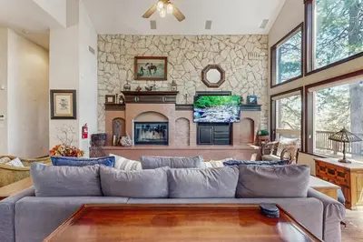a living room with a large couch and a fireplace at Summit Sanctuary in Lake Arrowhead