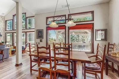 a dining room with a wooden table and chairs at Summit Sanctuary in Lake Arrowhead