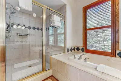 a bathroom with a shower and a tub and a sink at Summit Sanctuary in Lake Arrowhead