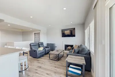 a living room with two couches and a fireplace at Seaspray at Anacapa View in Port Hueneme