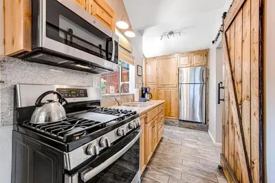 a kitchen with a stove with a tea kettle at Castle Rock Cabin #1 ~ Comfortable cabin with modern amenities and deck - near hiking and lake in Big Bear Lake