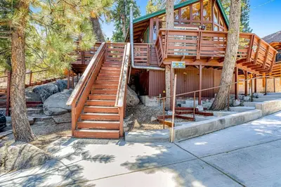 a house with stairs leading up to it with trees at Castle Rock Cabin #1 ~ Comfortable cabin with modern amenities and deck - near hiking and lake in Big Bear Lake