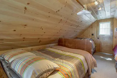 a log cabin with a bed in a room at Castle Rock Cabin #2 ~ Cozy cabin close to Fisher Cove & Boulder Bay - short drive to skiing in Big Bear Lake