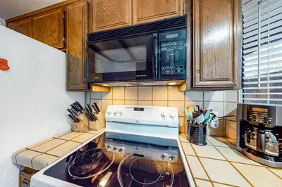 a kitchen with a stove and a microwave at Rosie's Hideaway ~ Spacious Retreat Near the Mountain & Lake with Grill & Full Kitchen in Big Bear Lake