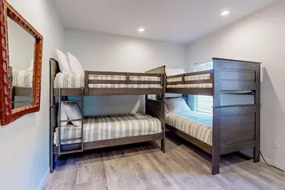 two bunk beds in a room with a mirror at Hillside Hideaway ~ Dog-friendly home with wraparound deck, grill, game room, & bar - walk to dining in Big Bear Lake