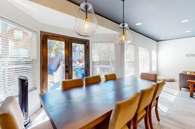a dining room with a large wooden table and chairs at Hillside Hideaway ~ Dog-friendly home with wraparound deck, grill, game room, & bar - walk to dining in Big Bear Lake