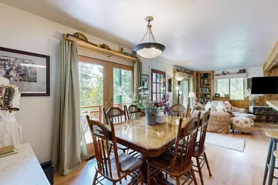 a dining room with a table and chairs at Rooster's Den ~ Charming house with expansive deck, cable, internet, near Big Bear Lake in Big Bear Lake