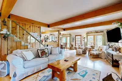 a living room with a couch and a table at Rooster's Den ~ Charming house with expansive deck, cable, internet, near Big Bear Lake in Big Bear Lake