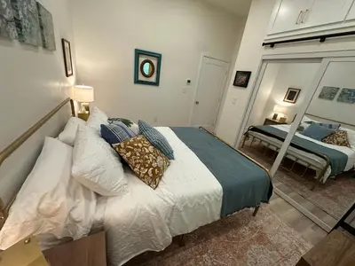 a bedroom with a bed with pillows and a mirror at Stylish Highland Park Home in Los Angeles