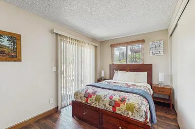 a bedroom with a large bed and a window at Meadow-Front Metcalf Bay Cabin Hot Tub, Air Hockey, Firepit & Lake Views in Big Bear Lake