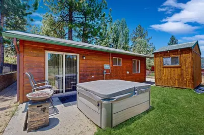 a small cabin with a bed in the yard at Meadow-Front Metcalf Bay Cabin Hot Tub, Air Hockey, Firepit & Lake Views in Big Bear Lake
