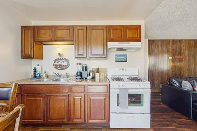 a kitchen with wooden cabinets and a white stove top oven at Meadow-Front Metcalf Bay Cabin Hot Tub, Air Hockey, Firepit & Lake Views in Big Bear Lake
