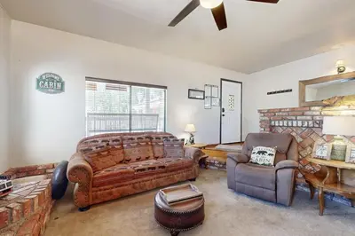 a bedroom with a large bed and a couch and chair at Lazy Bear Cabin ~ Dog-friendly home with private hot tub, ping-pong, basketball & firepit in Big Bear Lake