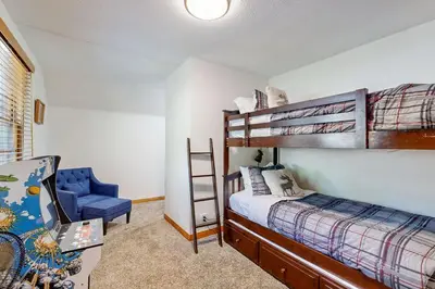 a bedroom with a bunk bed and a blue chair at Quiet Cabin ~ End of Cul-De-Sac Location Private Hot Tub, Fenced Yard, Boat Parking in Big Bear Lake