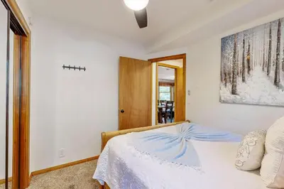 a bedroom with a white bed and a picture on the wall at Quiet Cabin ~ End of Cul-De-Sac Location Private Hot Tub, Fenced Yard, Boat Parking in Big Bear Lake