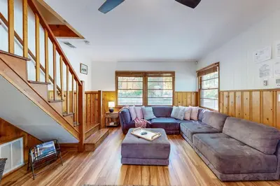 a living room with a couch and a staircase at Quiet Cabin ~ End of Cul-De-Sac Location Private Hot Tub, Fenced Yard, Boat Parking in Big Bear Lake