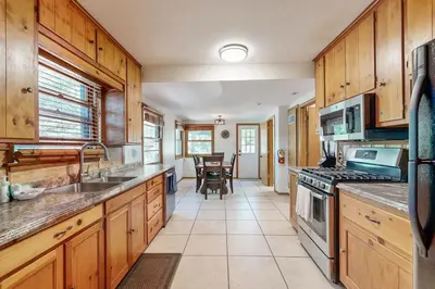 a kitchen with wooden cabinets and a stove top oven at Quiet Cabin ~ End of Cul-De-Sac Location Private Hot Tub, Fenced Yard, Boat Parking in Big Bear Lake