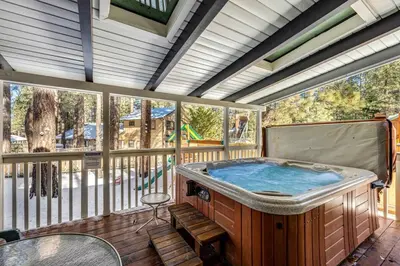 a large hot tub on a screened in porch at Moose-in' Around ~ Walk to Slopes Mountain Home with Private Hot Tub, Ski Locker & Playground in Big Bear Lake