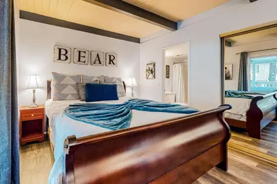 a bedroom with a bed and a mirror at Moose-in' Around ~ Walk to Slopes Mountain Home with Private Hot Tub, Ski Locker & Playground in Big Bear Lake