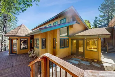 a house with a wooden deck with a porch at Big Bear 7th Heaven ~ Lakeview Chalet with Hot Tub, Sauna, Grill, Great Deck Views in Fawnskin