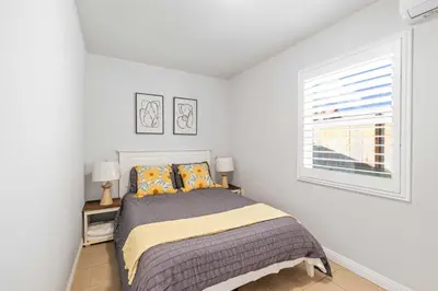 a white bedroom with a bed and a window at #Marbella lane - Serene Haven Retreat 3BR in Ontario