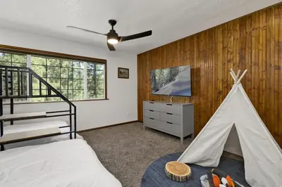 a bedroom with a bed and a play tent at The Fox Den Big Bear ~ Modern Mountain View Retreat w/ Hot Tub in Big Bear City