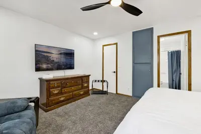 a bedroom with a bed and a tv and a couch at The Fox Den Big Bear ~ Modern Mountain View Retreat w/ Hot Tub in Big Bear City