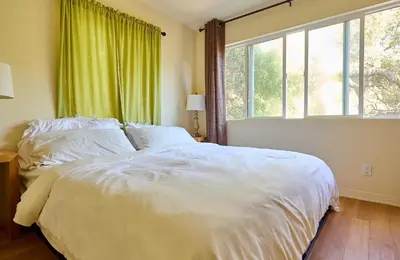 a bedroom with a white bed and a large window at Malibu Nature Escape - 2BR Hideaway Nestled in the Woods, Minutes from the Beach in Malibu
