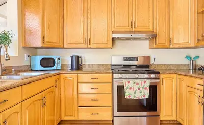 a kitchen with wooden cabinets and a stove top oven at Malibu Nature Escape - 2BR Hideaway Nestled in the Woods, Minutes from the Beach in Malibu