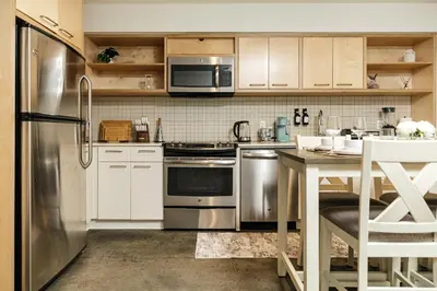 a kitchen with stainless steel appliances and a table at Palm & Vine MODERN COZY LOFT in HOLLYWOOD, FREE Parking in Los Angeles