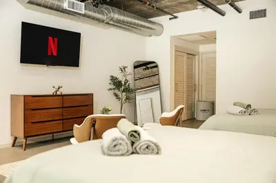 a bedroom with two beds and a tv on the wall at Palm & Vine MODERN COZY LOFT in HOLLYWOOD, FREE Parking in Los Angeles