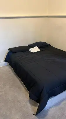 a bed with a black comforter in a room at ElMonte Soul in El Monte