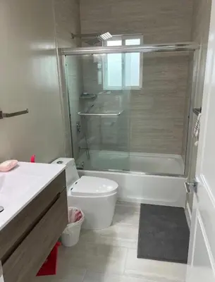 a bathroom with a toilet and a glass shower at ElMonte Soul in El Monte