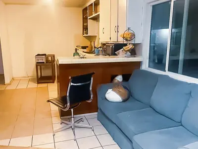 a living room with a blue couch and a kitchen at ElMonte Soul in El Monte