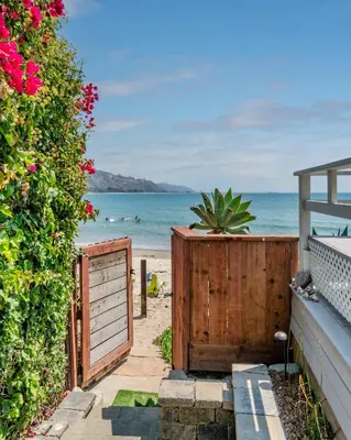 a pathway to the beach with a wooden gate and a fence at The Cove at Rincon by Paradise Retreats in Carpinteria