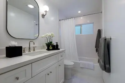 a bathroom with a sink and a toilet and a mirror at The Cove at Rincon by Paradise Retreats in Carpinteria
