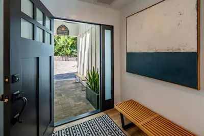a hallway with a door and a bench and a picture at The Cove at Rincon by Paradise Retreats in Carpinteria