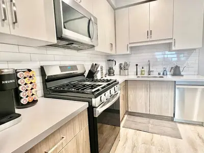 a kitchen with white cabinets and a stove top oven at Silver Lake 1 Bedroom Condo Suite with Balcony and Parking in Los Angeles