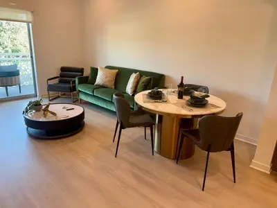 a living room with a green couch and a table at Silver Lake 1 Bedroom Condo Suite with Balcony and Parking in Los Angeles