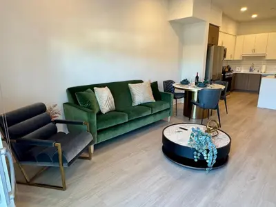 a living room with a green couch and a table at Silver Lake 1 Bedroom Condo Suite with Balcony and Parking in Los Angeles