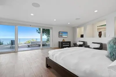 a bedroom with a large bed and a view of the ocean at Malibu Oceana Bleu by Stay Awhile Villas in Malibu Beach