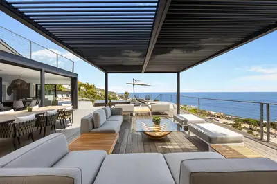 an outdoor patio with couches and a view of the ocean at Malibu Oceana Bleu by Stay Awhile Villas in Malibu Beach