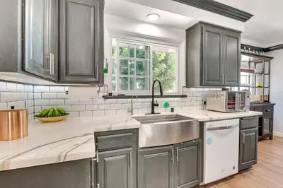 a kitchen with gray cabinets and a sink at Relax Fireside Hacienda Heights Gem with Patio! in Hacienda Heights