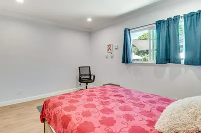 a bedroom with a pink bed and a window at Relax Fireside Hacienda Heights Gem with Patio! in Hacienda Heights