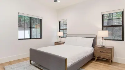 a white bedroom with a bed and two windows at Luxury Retreat 5mins to the Lake Game Room Fire Pit Howlite by AvantStay in Lake Arrowhead