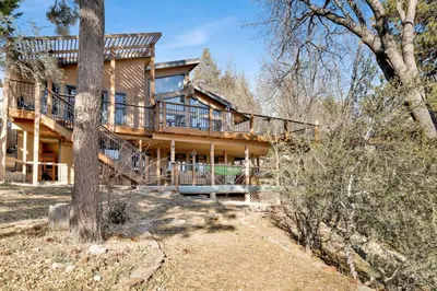 a large house with a deck in the woods at Big Bear 7th Heaven #714 in Fawnskin